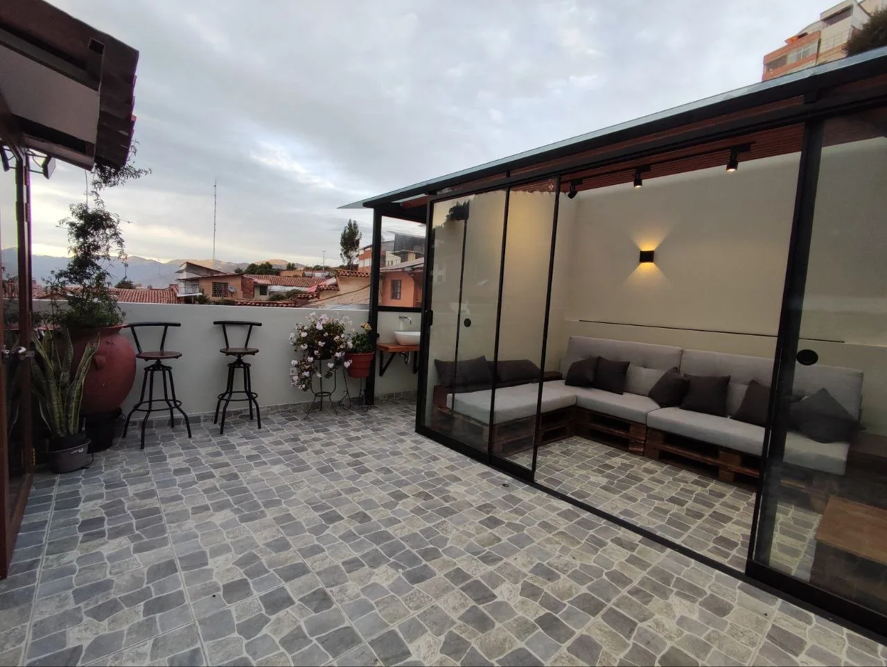 Terraza de Casa Agustina con sillones, mesas y vistas a los tejados de Cusco