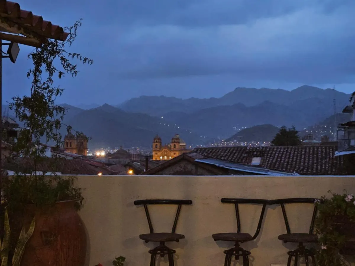 Cusco al anochecer, con las torres de las iglesias iluminadas, visto desde la terraza